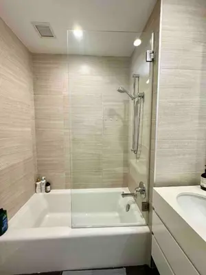 a white bathroom with a tub and a sink at 1 Stop to Midtown Amazing View Luxury High Rise Corner 1 Bedroom Apartment in Sunnyside