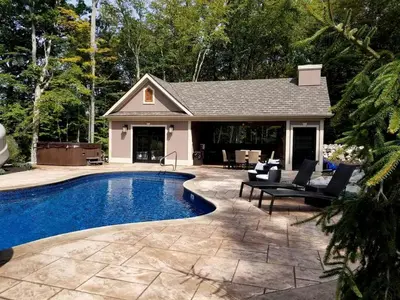 a swimming pool in front of a house at Glamorous Cottage Rental with Outdoor Lounge and Pool on 40 Acres in Pine Bush, New York in Pine Bush