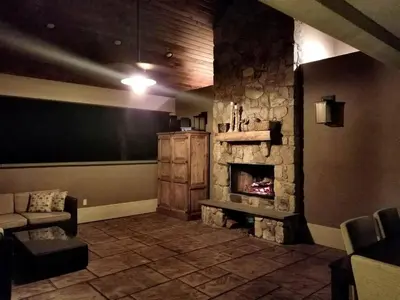 a living room with a stone fireplace and a couch at Glamorous Cottage Rental with Outdoor Lounge and Pool on 40 Acres in Pine Bush, New York in Pine Bush