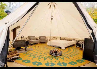 a room with a tent with a bed and a tv at Piebald Mountain Pet Friendly Tents, Petersburg, New York