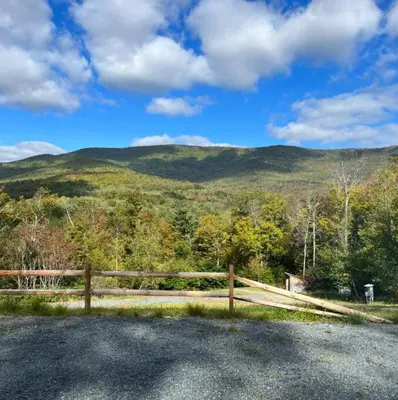 a wooden fence with a view of a mountain at Piebald Mountain Pet Friendly Tents, Petersburg, New York