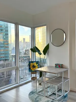 a room with a table and a mirror and a window at 5 mins to Midtown Central New Luxury Corner 2b2b Apt with Amazing City View in Long Island City