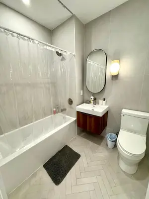 a bathroom with a tub and a toilet and a sink at 5 mins to Midtown Central New Luxury Corner 2b2b Apt with Amazing City View in Long Island City