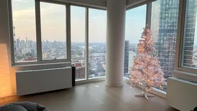 a living room with a christmas tree in a room with windows at Luxury 2 bedrooms 2 bathrooms Corner Apartment Breathtaking City Views Modern Retreat in Sunnyside