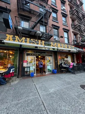 a store front of a building with people sitting in chairs outside at Midtown High Floor Fantastic Panoramic City View Corner 2 Bedroom Apartment in New York