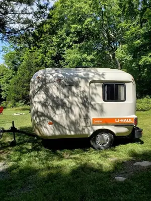a trailer parked in the grass in a field at Unique Caravan for Vintage Glamping Experience in Pine Bush, New York in Pine Bush