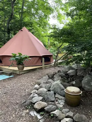 a tent and a pile of rocks next to a yard at Romantic Botanical Bell Tent for a Fantastic Glamping Experience in Southbury, Connecticut in Southbury