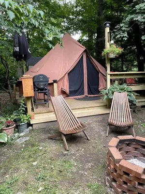 a tent with two chairs and a grill in a yard at Romantic Botanical Bell Tent for a Fantastic Glamping Experience in Southbury, Connecticut in Southbury