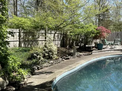 a swimming pool in a yard next to a fence at Romantic Botanical Bell Tent for a Fantastic Glamping Experience in Southbury, Connecticut in Southbury