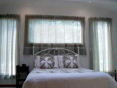 a bedroom with a bed with two windows at Lovely Cottage Getaway in the Mountains near Phoenicia, New York in Chichester