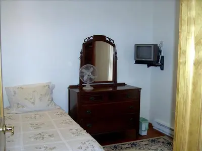 a bedroom with a bed and a mirror and a tv at Lovely Cottage Getaway in the Mountains near Phoenicia, New York in Chichester
