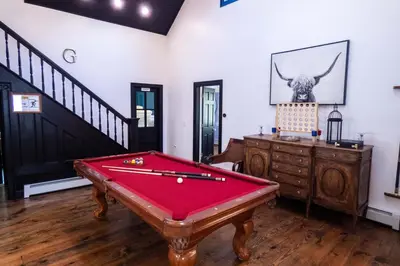 a room with a pool table and a staircase at Chic Catskills Farmhouse in Harris