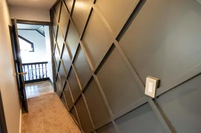 a hallway with a wall with a wooden accent wall at Chic Catskills Farmhouse in Harris