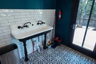 a bathroom with a sink and a tile floor at Chic Catskills Farmhouse in Harris