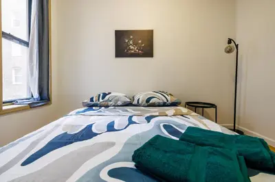 a bedroom with a bed with a green blanket on it at Discover the Comfort of Columbia University Area-4 in New York