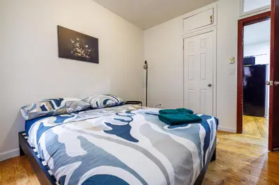 a bedroom with a bed with a blue and white comforter at Discover the Comfort of Columbia University Area-4 in New York