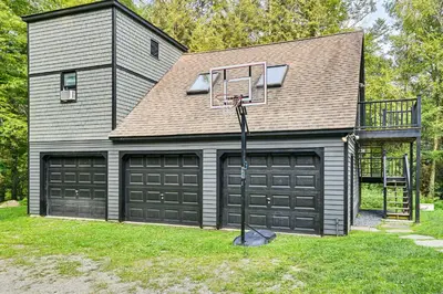 a house with two garage doors and a basketball hoop at 8 Mi to Tanglewood and Butternut Ski Spacious Home! in Housatonic