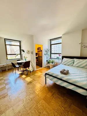 a bedroom with a bed and a desk in it at Midtown Park Ave Charming Chrysler View Corner Studio in New York