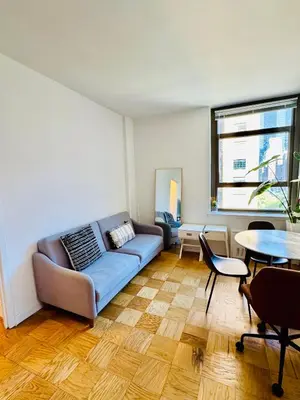 a living room with a couch and a table at Midtown Park Ave Charming Chrysler View Corner Studio in New York