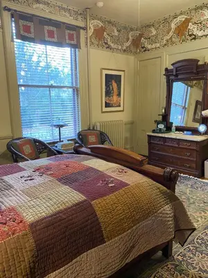 a bedroom with a bed and a dresser and a mirror at Amherst Inn in Amherst