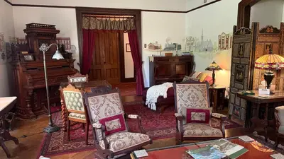 a bedroom with a bed and a piano and chairs at Amherst Inn in Amherst