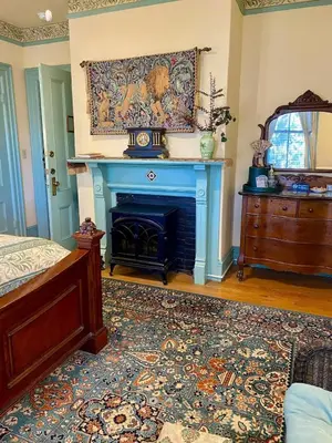 a bedroom with a fireplace and a bed and a rug at Amherst Inn in Amherst
