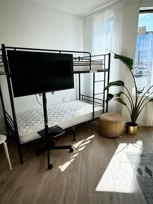 a bedroom with a bunk bed with a flat screen tv at Peaceful Quiet Spacious New Modern Penthouse 3-Bedroom Apartment with a Balcony in Brooklyn