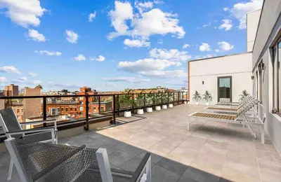 a balcony with chairs and a view of a city at Peaceful Quiet Spacious New Modern Penthouse 3-Bedroom Apartment with a Balcony in Brooklyn