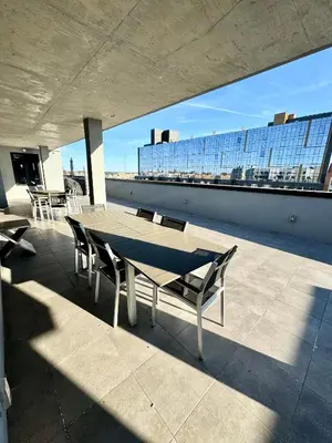 a table and chairs on the roof of a building at Peaceful Quiet Spacious New Modern Penthouse 3-Bedroom Apartment with a Balcony in Brooklyn