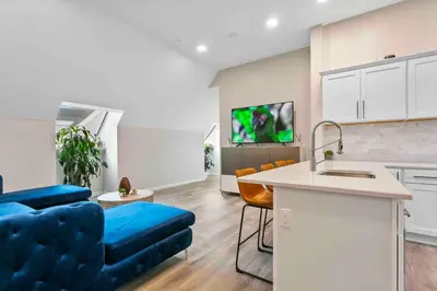 a living room with a blue couch and a kitchen at Stylish Comfort Wooster Square Yale Wi-Fi in New Haven