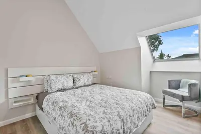 a bedroom with a bed and a chair and a window at Stylish Comfort Wooster Square Yale Wi-Fi in New Haven
