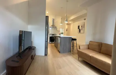 a living room with a couch and a kitchen at Modern 3BR,2BA Apartment in Jersey City, Easy Access to Manhattan in Jersey City
