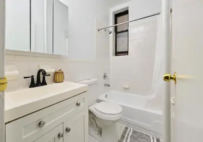 a white bathroom with a toilet and a tub and a sink at Studio for 2! Heart of Midtown! in New York