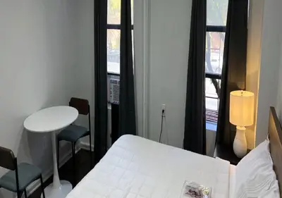 a room with a bed and a table and a window at Upper E Side Spacious Studio! in New York