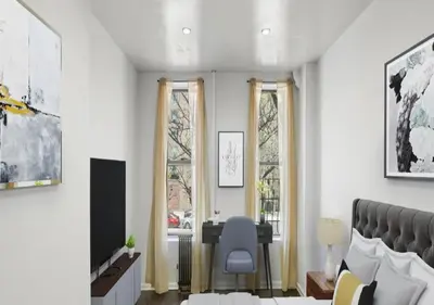 a living room with a chair and two windows at Upper E Side Spacious Studio! in New York