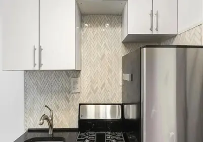 a kitchen with a stove and a refrigerator at Upper E Side Spacious Studio! in New York