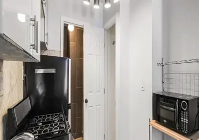 a kitchen with a stove and a microwave at Upper E Side Spacious Studio! in New York
