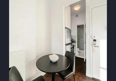 a dining room with a black table and chairs at Modern Studio Apartment in NYC! in New York
