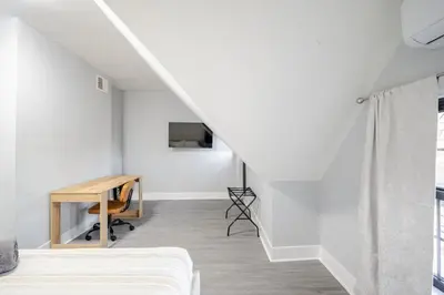 a room with a bed and a desk and a staircase at 2 Bed Apt in BlackRock by beach in Bridgeport