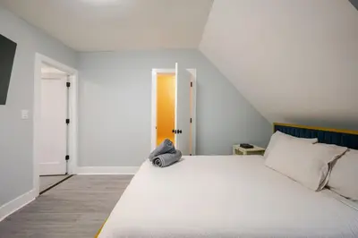a bedroom with a large white bed and an open door at 2 Bed Apt in BlackRock by beach in Bridgeport