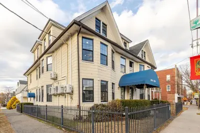 a white house with a black roof at 2 Bed Apt in BlackRock by beach in Bridgeport