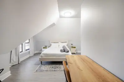 a white bedroom with a bed and a wooden table at 2 Bed Apt in BlackRock by beach in Bridgeport