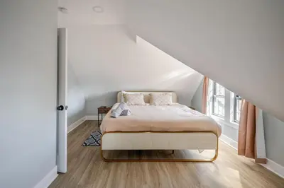 a white bedroom with a bed in a attic at Lrg 2 Bedroom apart in BlackRock in Bridgeport