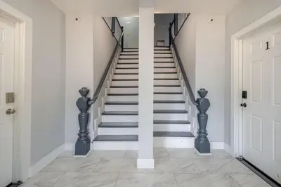 a staircase in a house with white walls and a white door at Lrg 2 Bedroom apart in BlackRock in Bridgeport