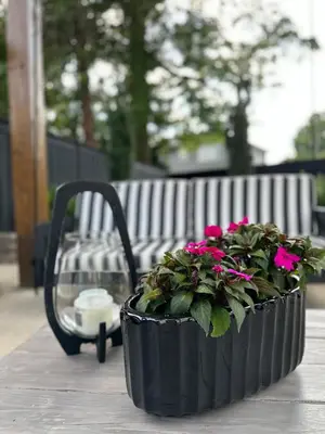 a planter with pink flowers sitting next to a bench at Luxurious Home Away from Home ! 30 minutes to NYC ! in Rochelle Park