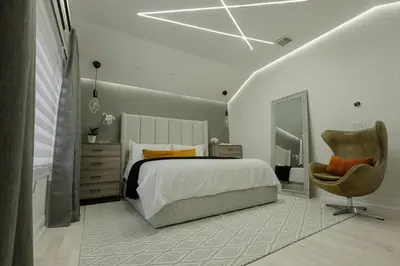a bedroom with a large bed and a chair at Luxurious Home Away from Home ! 30 minutes to NYC ! in Rochelle Park