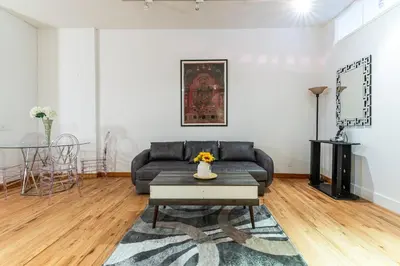a living room with a couch and a table at XL Prime Tribeca Furnished Loft, June To Aug 90 Days Stay Required in New York