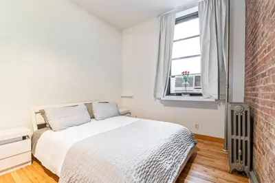 a white bedroom with a bed and a window at XL Prime Tribeca Furnished Loft, June To Aug 90 Days Stay Required in New York