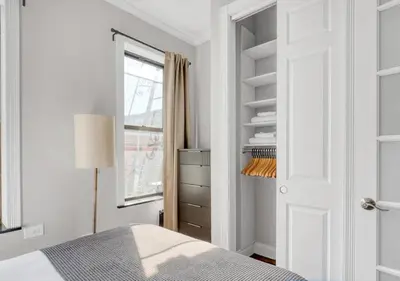 a white bedroom with a bed and a window at Midtown West Furnished Apartment 3BR in New York