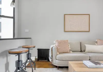 a living room with a couch and a stool at Midtown West Furnished Apartment 3BR in New York